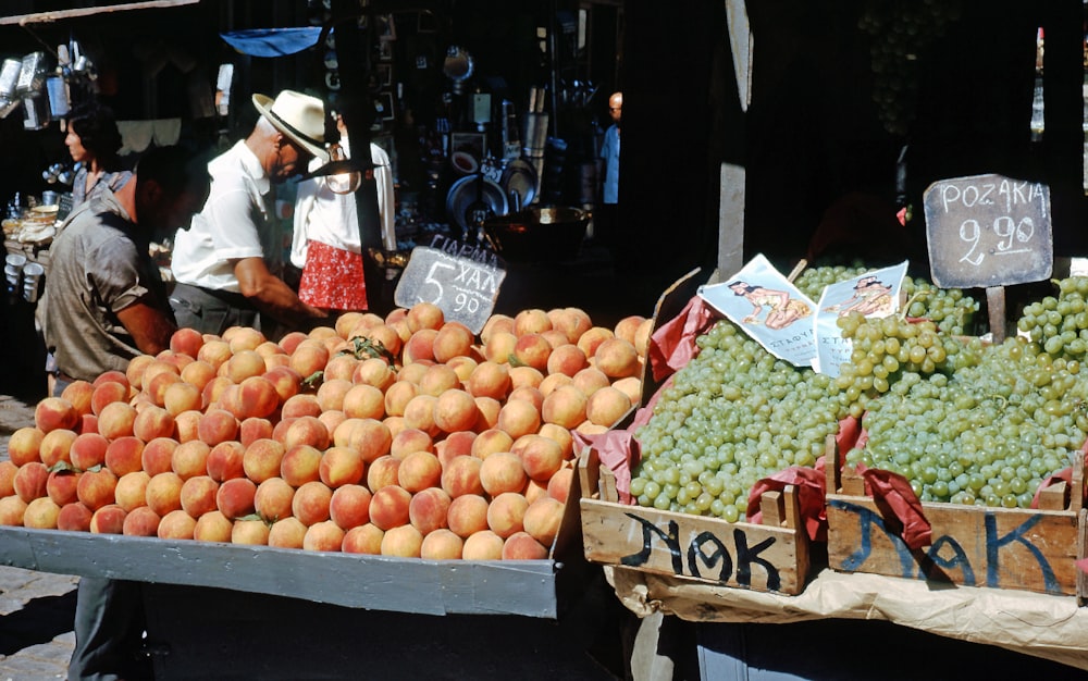 a fruit stand with oranges and grapes for sale