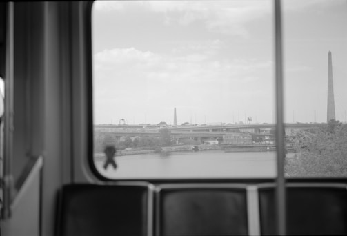 City skyline viewed through the large windows of a moving bus, capturing the essence of travel.