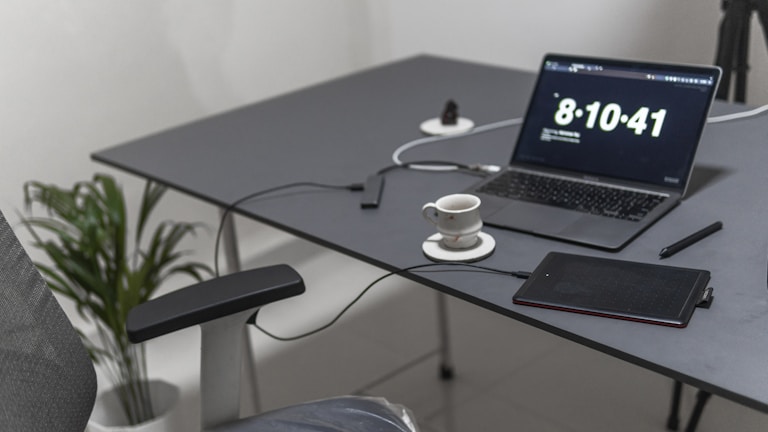 Minimalist workspace featuring tech gadgets and a cup of coffee.