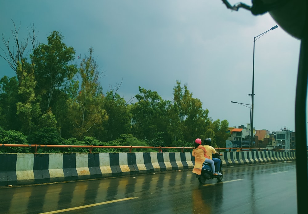 a couple of people riding on the back of a motorcycle