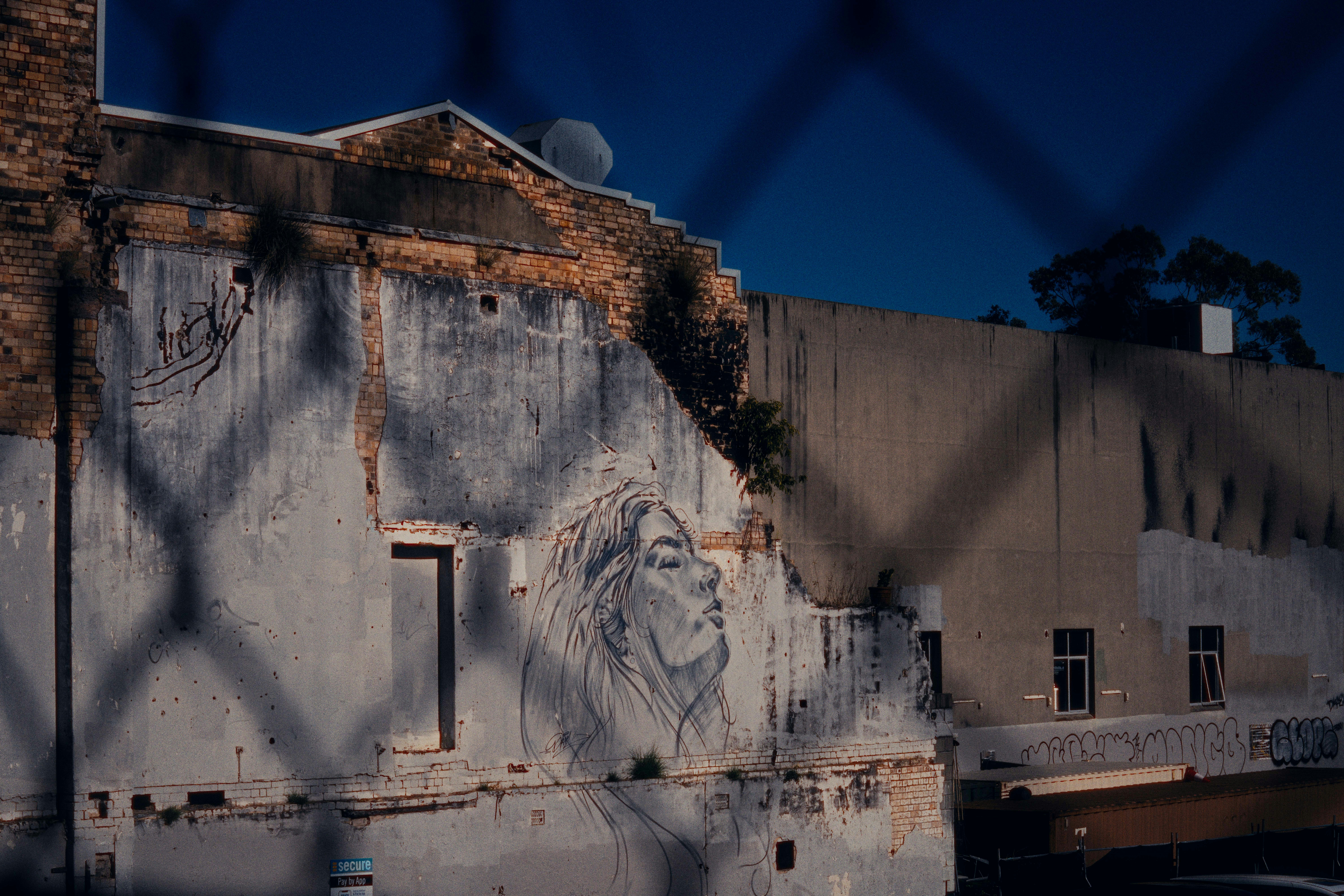 a building with graffiti on it behind a chain link fence