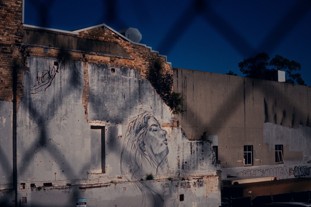 a building with graffiti on it behind a chain link fence