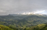 Lush green rice terraces cascading down the hillsides near Sapa under a misty sky.