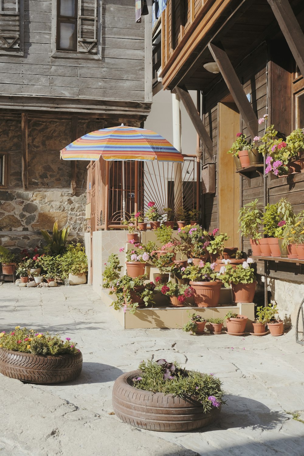 a patio with potted plants and an umbrella