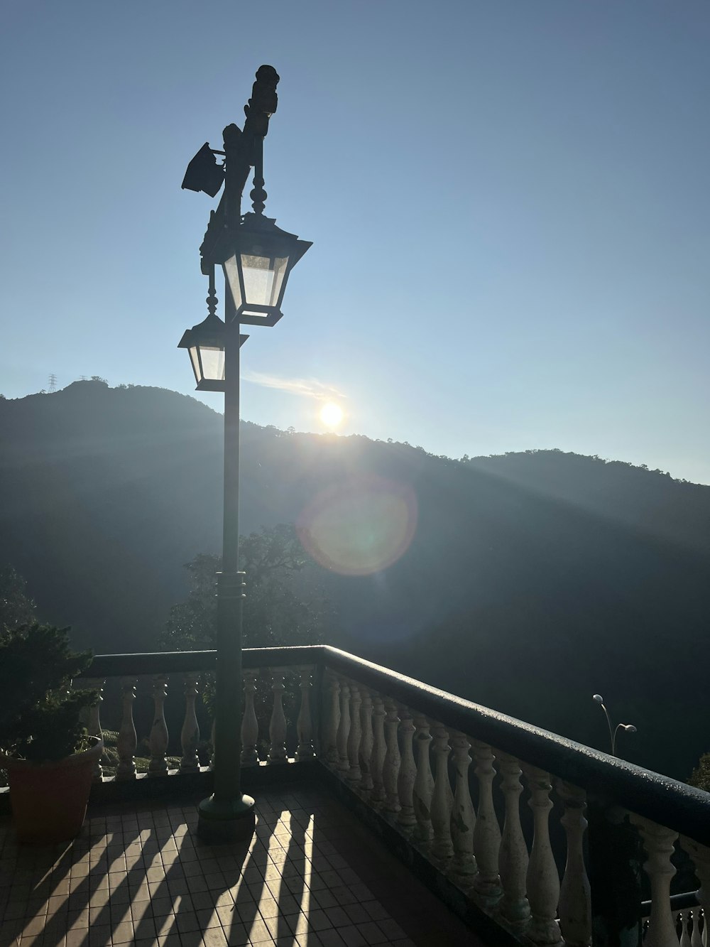 a lamp post on a balcony with a view of the mountains