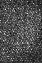 A textured surface of transparent bubble wrap with evenly distributed small air-filled bubbles.