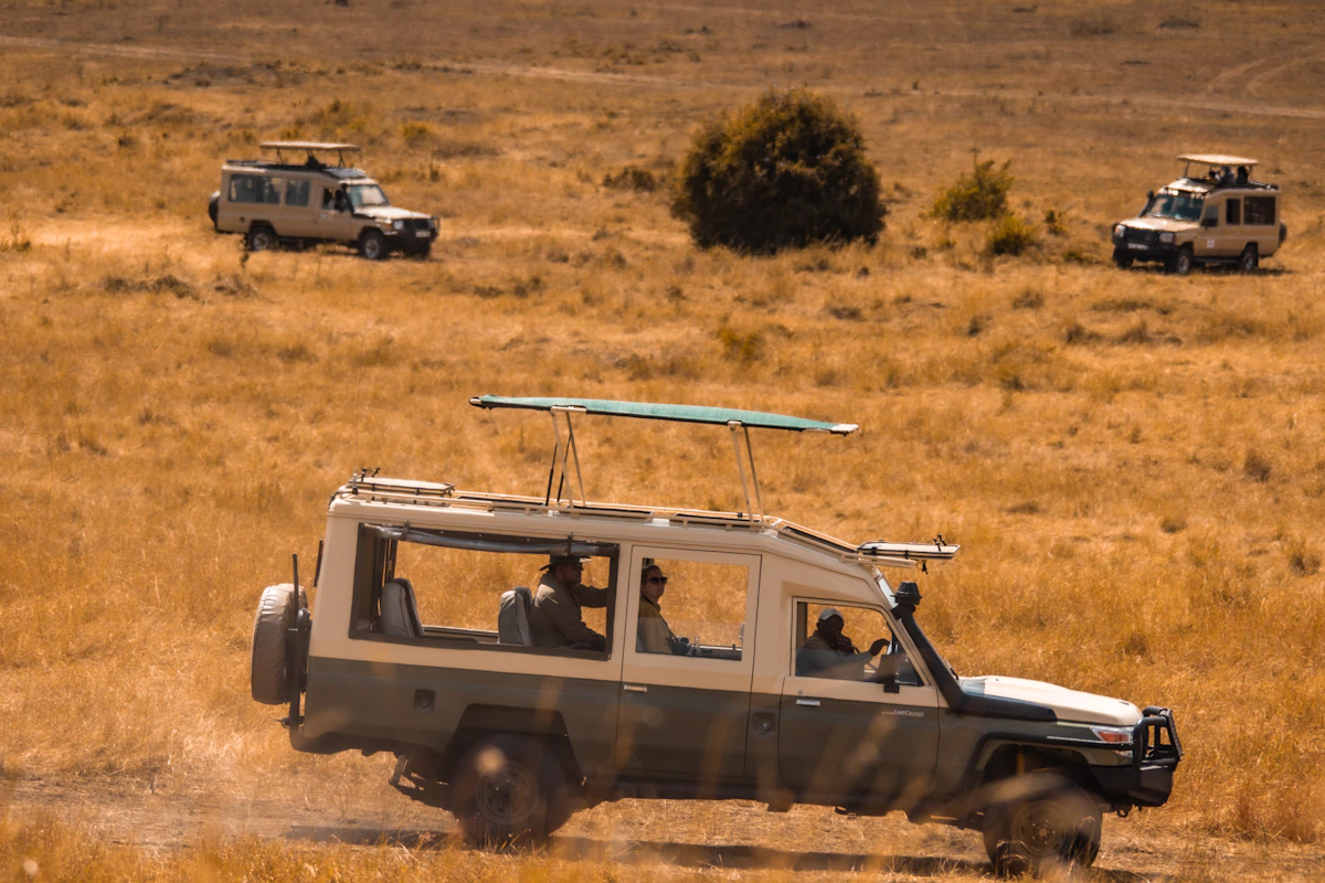 Safari vehicle driving through a dry grassland landscape in Tanzania