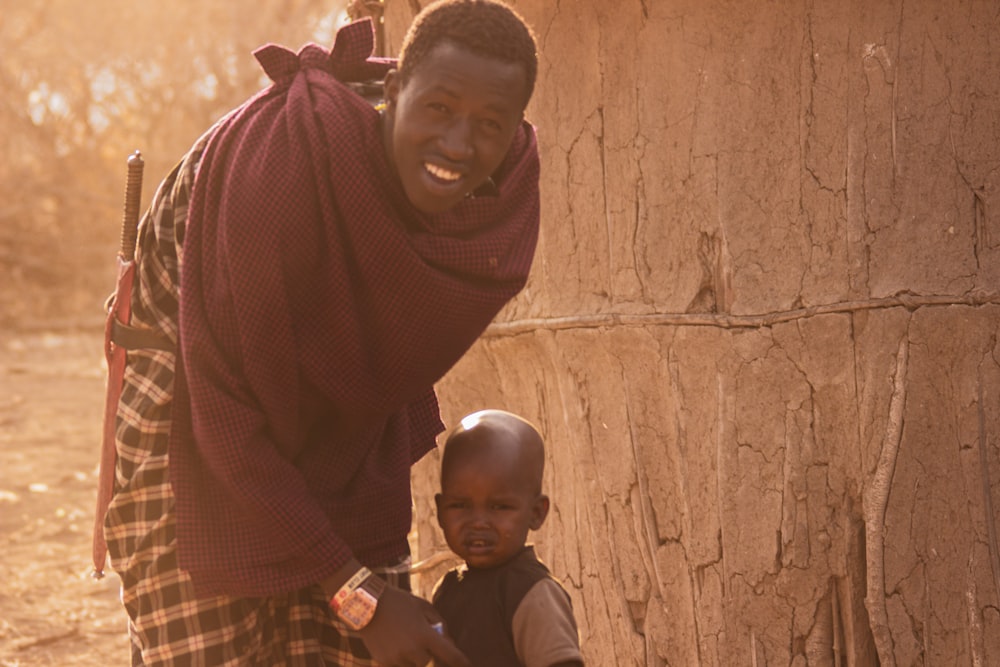 a man and a child standing next to a tree