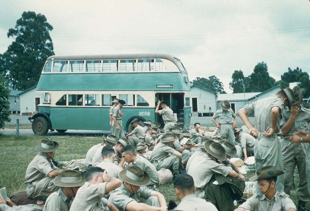 a group of men in uniform sitting in front of a bus