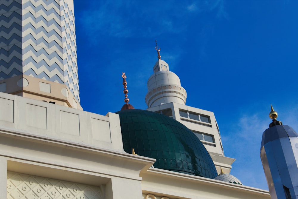 a tall white building with a green dome on top