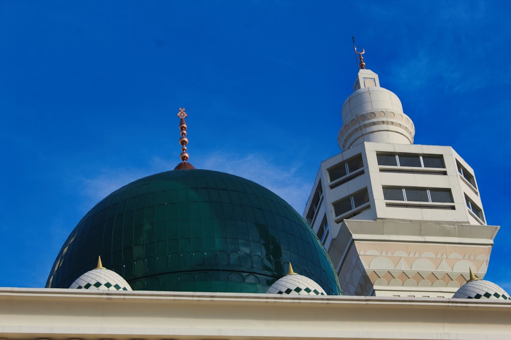 a green dome on top of a white building