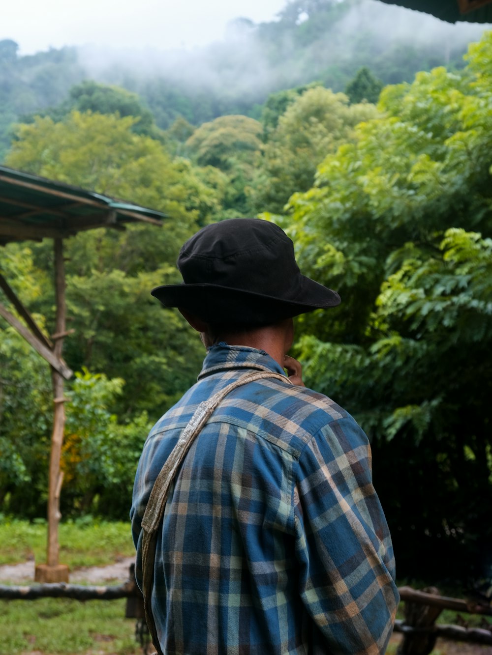 a man in a plaid shirt and a black hat