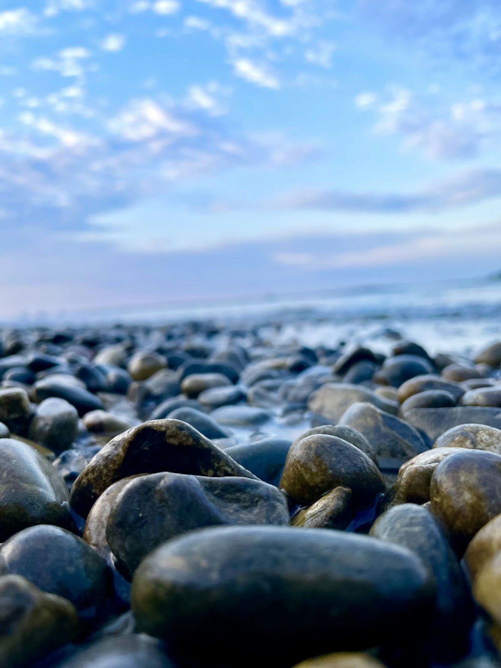 un mucchio di rocce sedute sulla cima di una spiaggia
