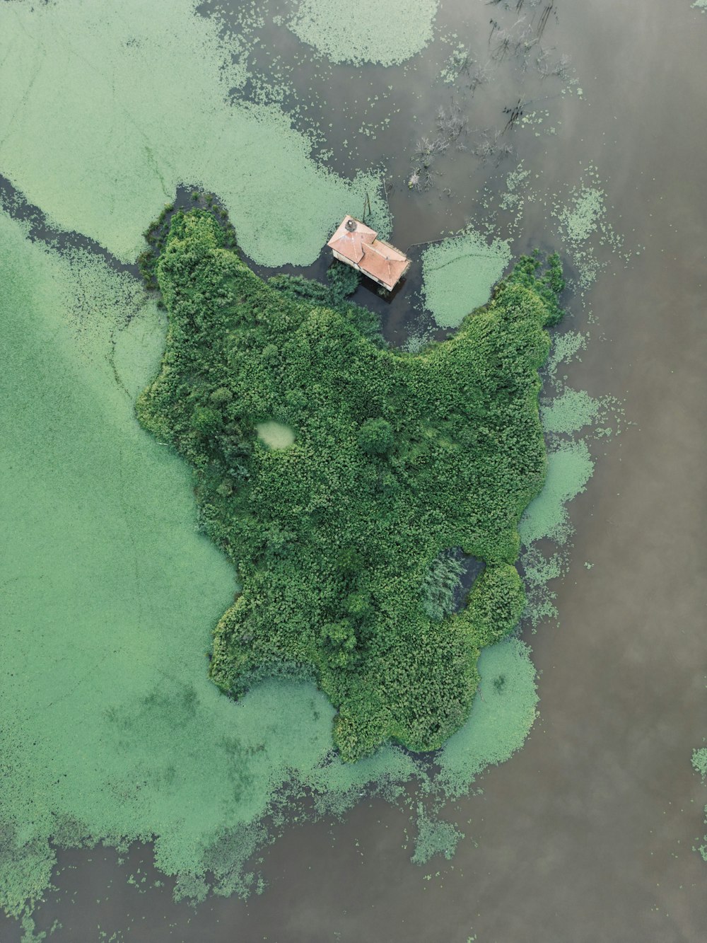 an aerial view of a house in the middle of the water