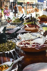 A vibrant market stall displaying fresh European food products like cheeses, olives, and cured meats.