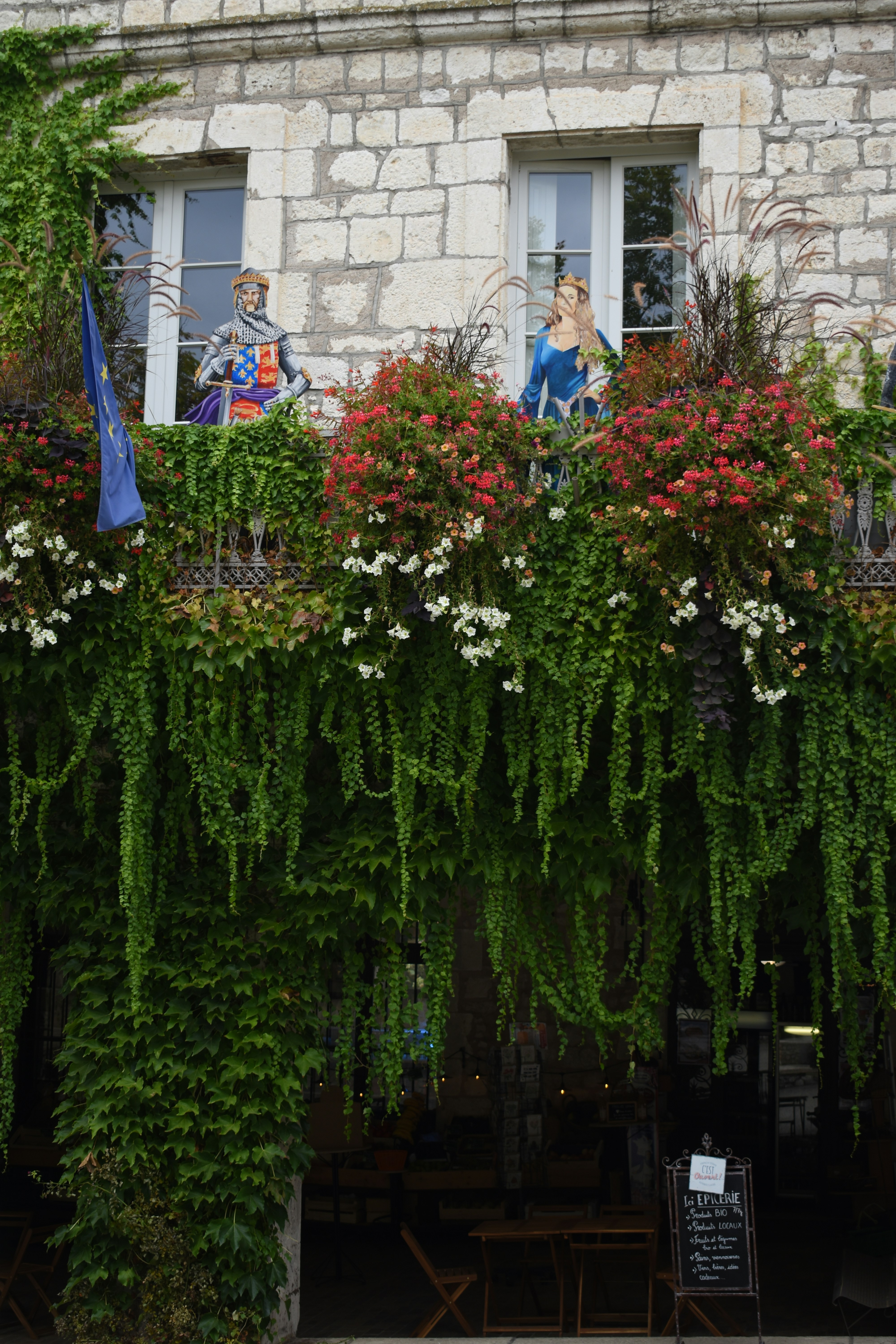 un bâtiment avec un bouquet de fleurs qui poussent dessus