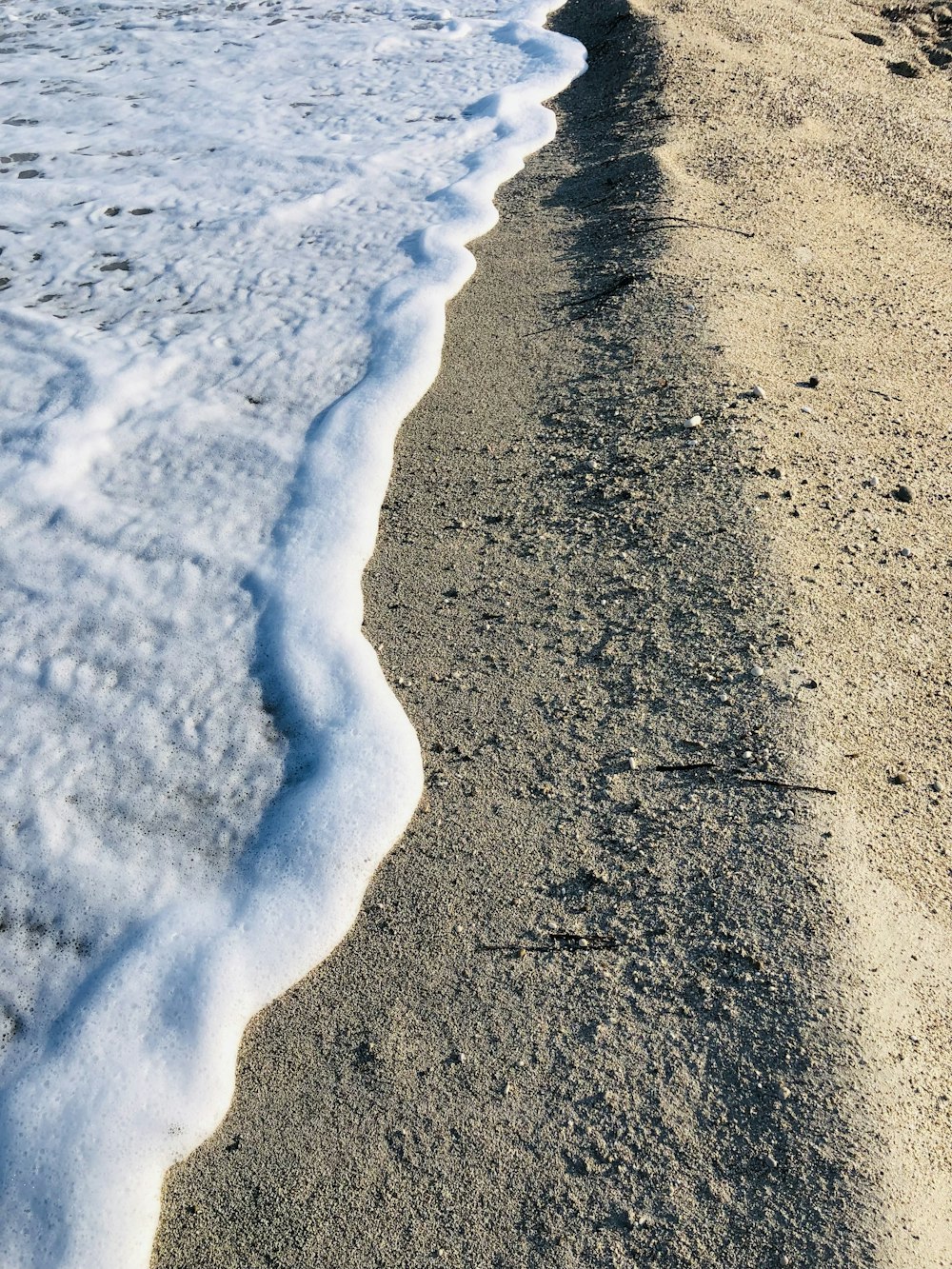 a sandy beach with waves coming in to shore