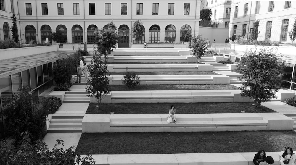 a black and white photo of a person walking in a courtyard