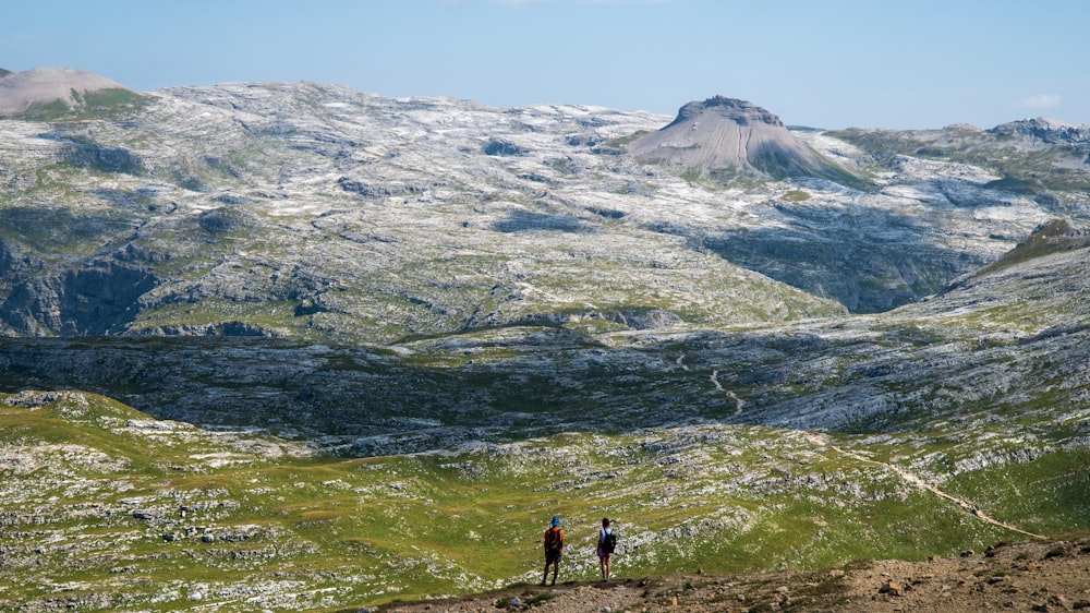 a couple of people standing on top of a mountain