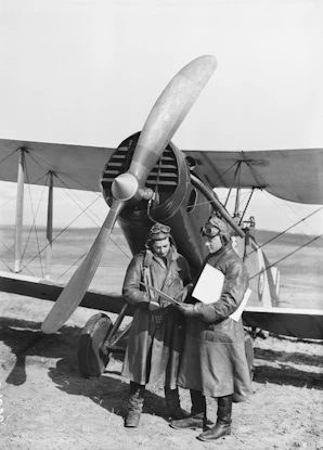 a couple of men standing next to an airplane