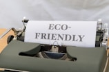 a close up of a typewriter with a paper that reads eco - friendly