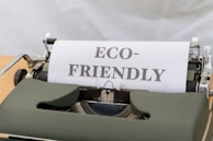 a close up of a typewriter with a paper that reads eco - friendly