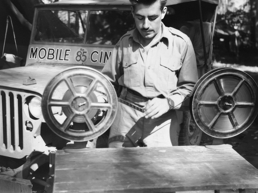 a man standing next to an old jeep