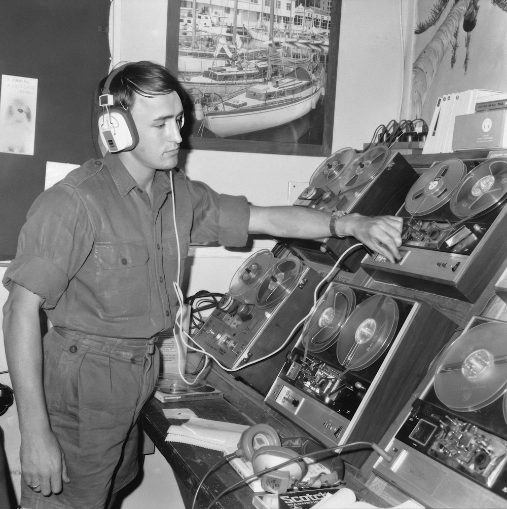 a man wearing headphones standing in front of a display of records