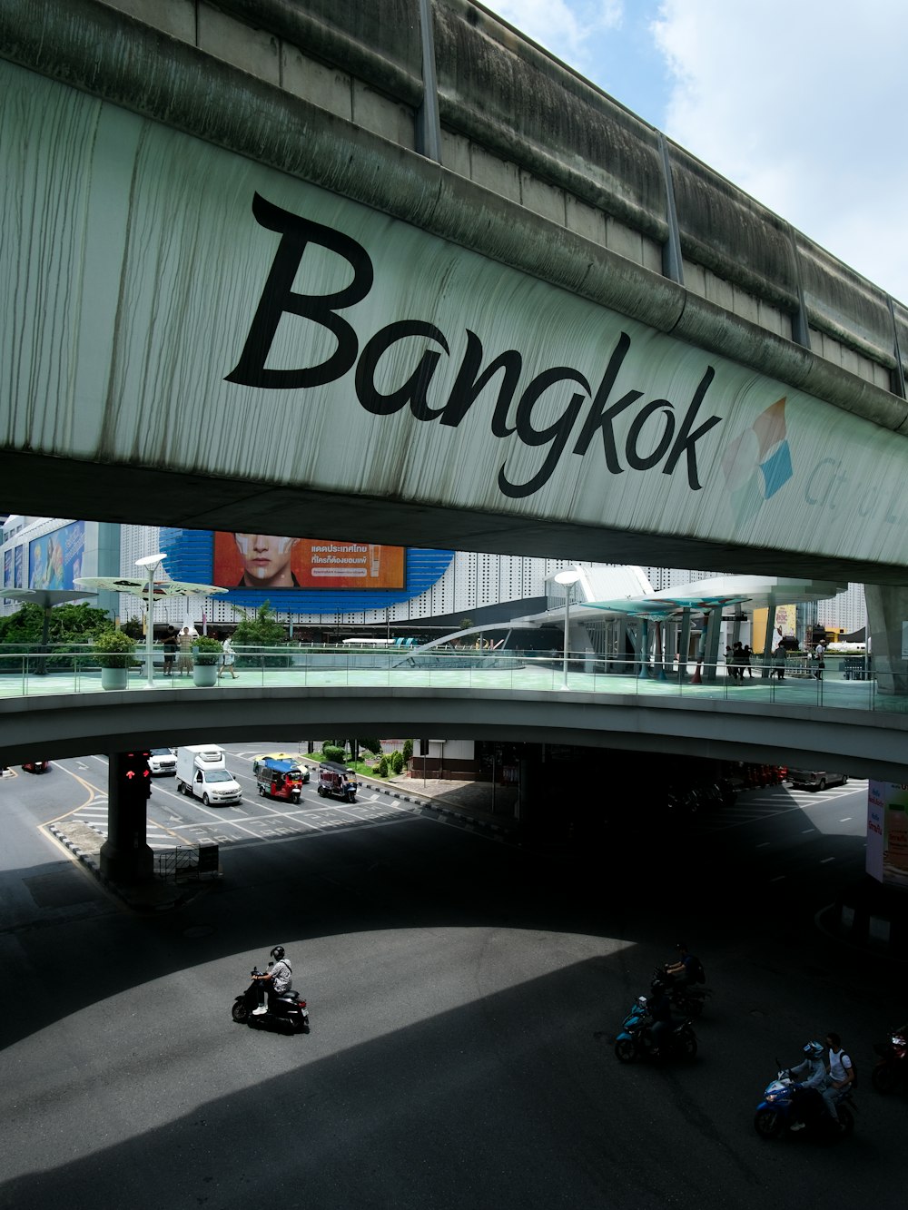 a group of motorcycles driving under a bridge