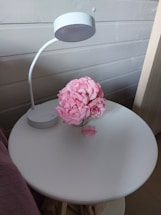 A welcoming office desk with a softly glowing lamp and a vase of fresh flowers.