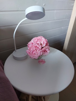 A welcoming office desk with a softly glowing lamp and a vase of fresh flowers.