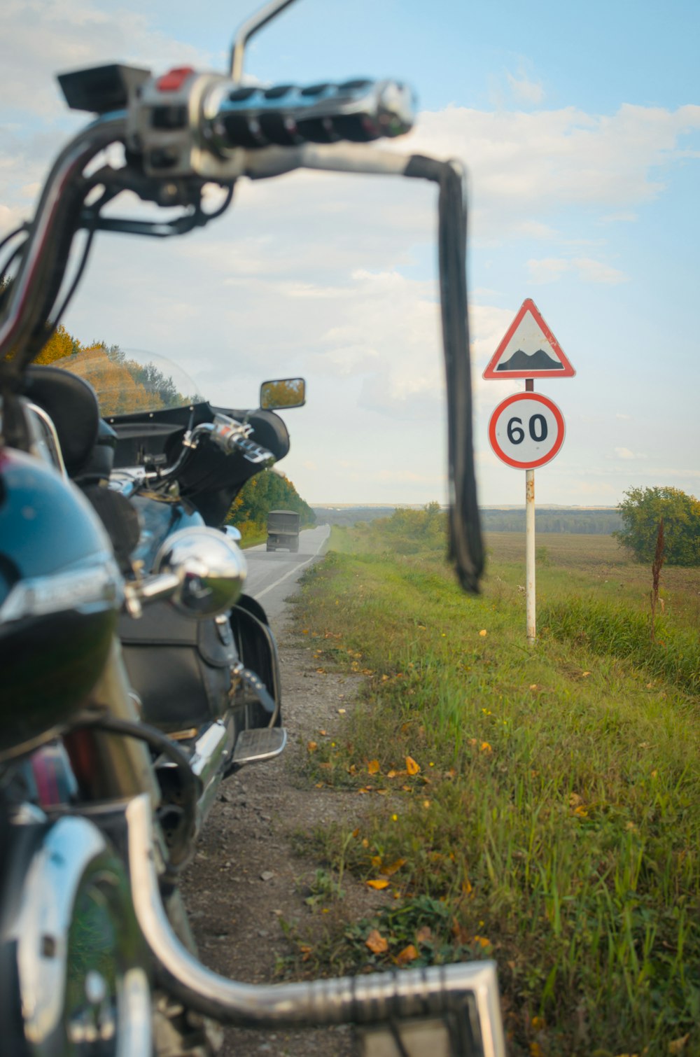 a motorcycle parked next to a speed limit sign