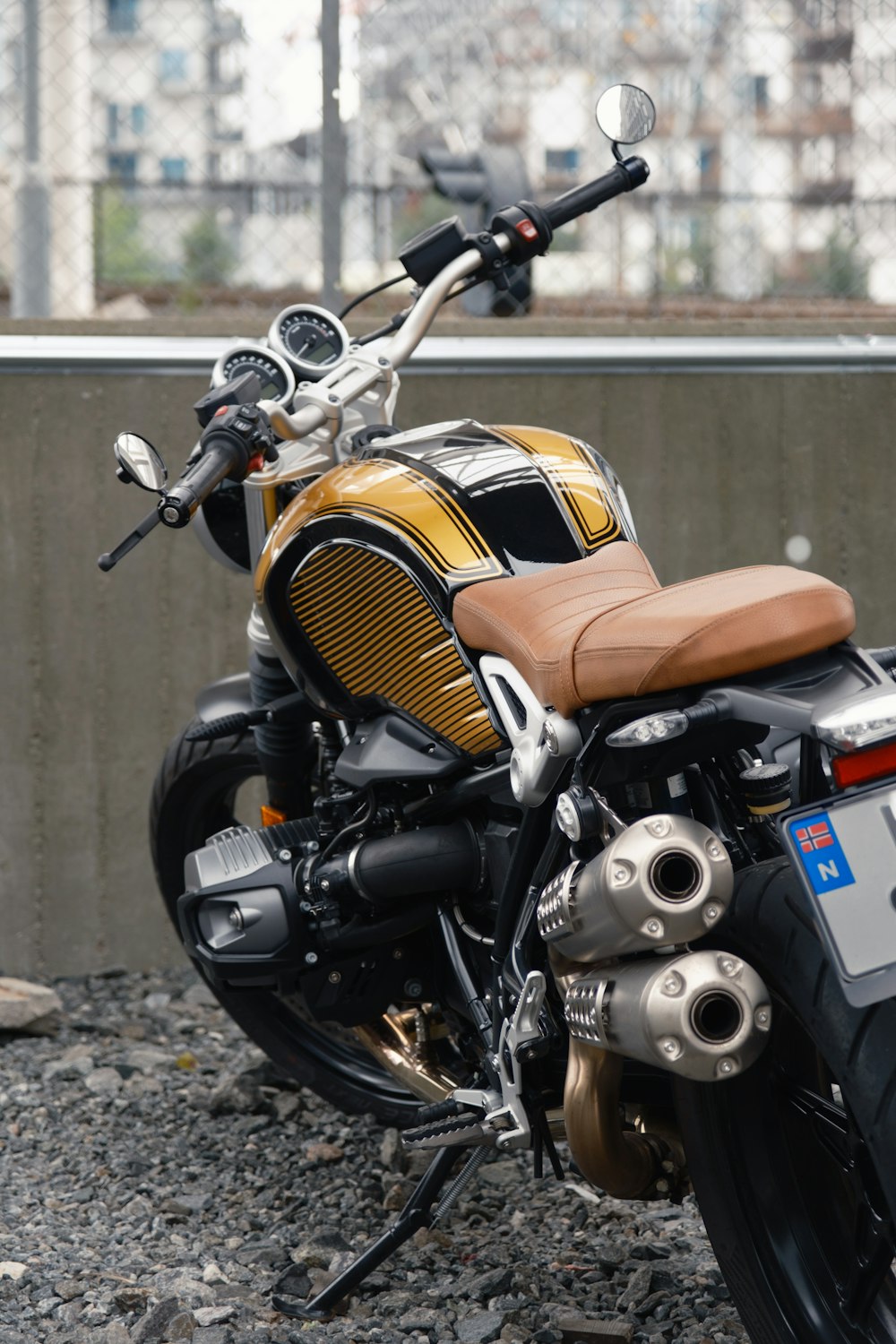 a yellow and black motorcycle parked next to a wall