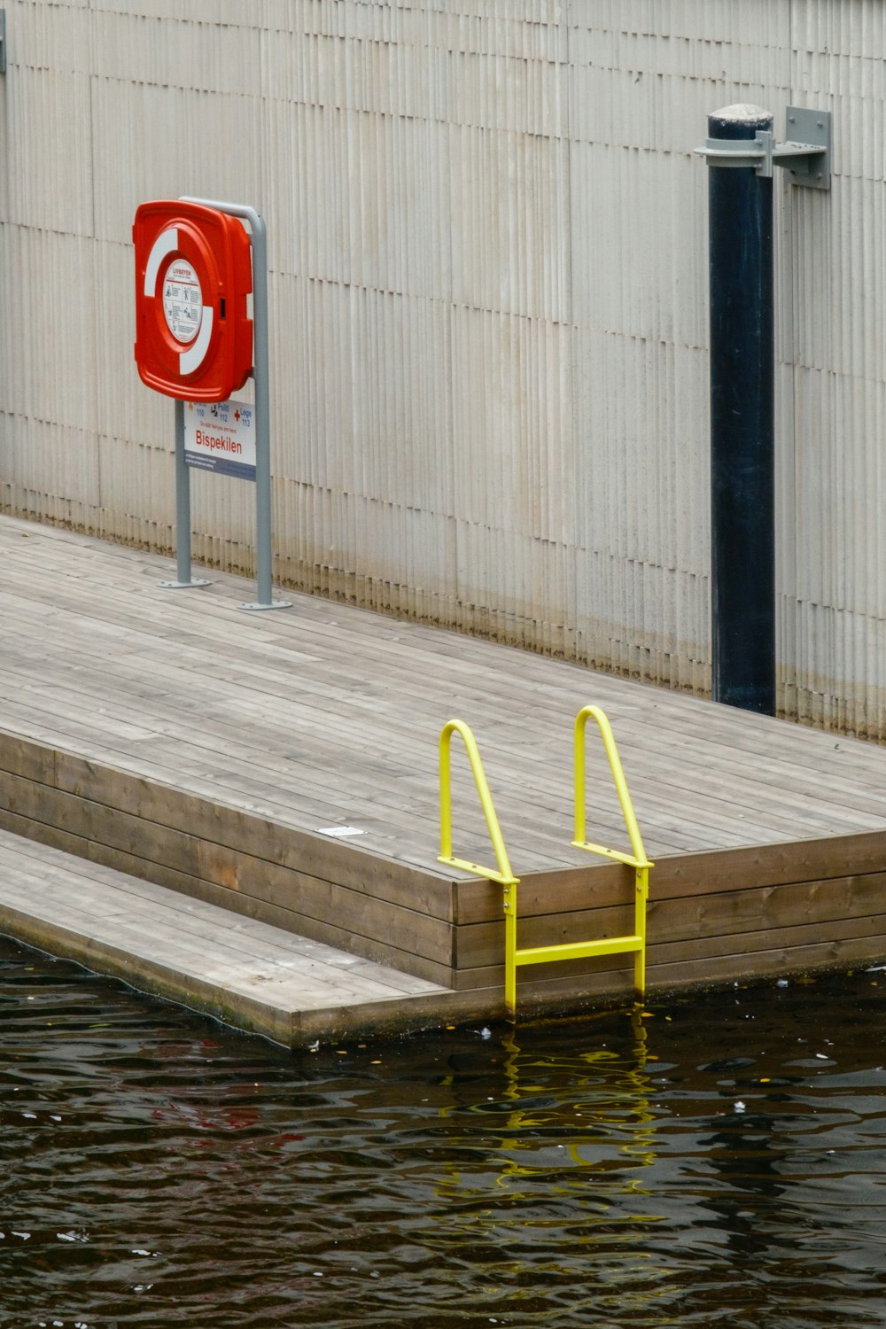 a dock with a yellow railing and a red fire hydrant