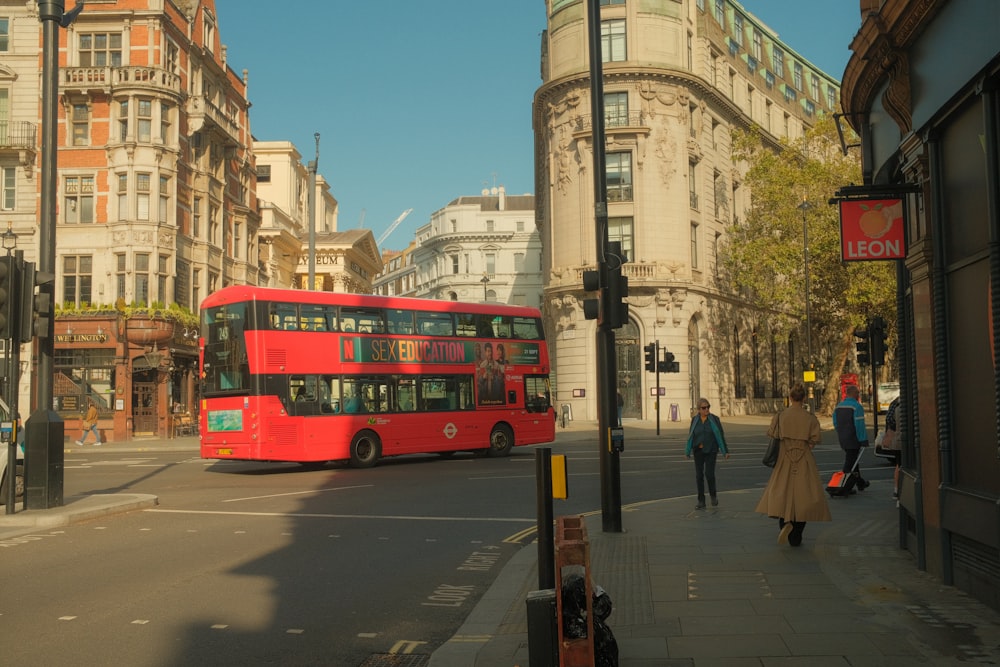 a red double decker bus driving down a street