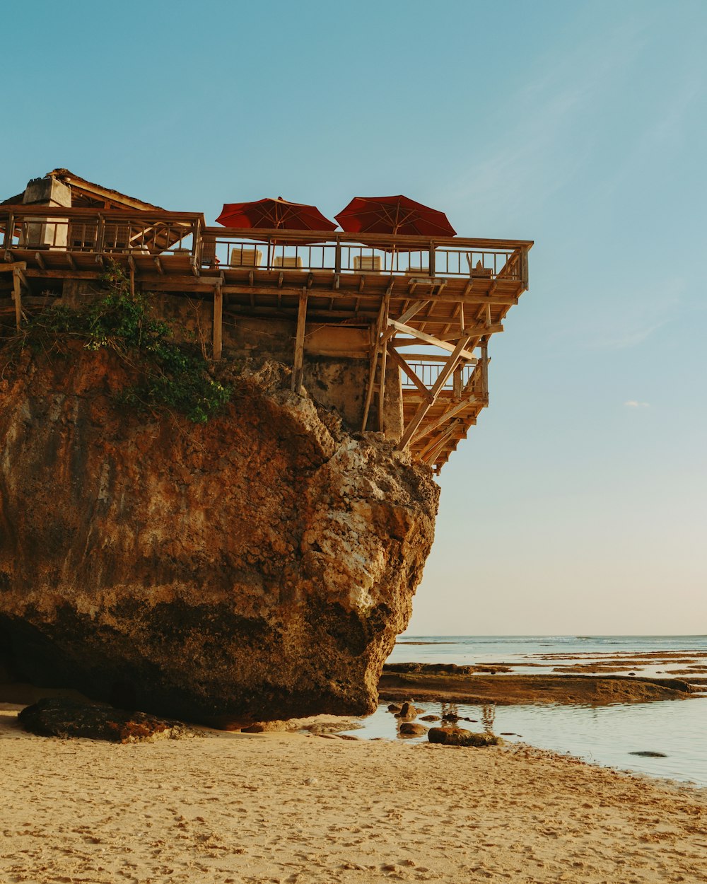 a large rock on a beach next to the ocean