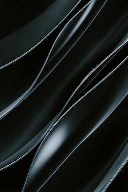 Smooth, flowing dark lines with a shiny, reflective surface creating an abstract pattern.