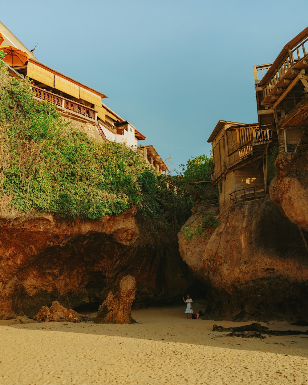 a person standing on a beach next to a cliff