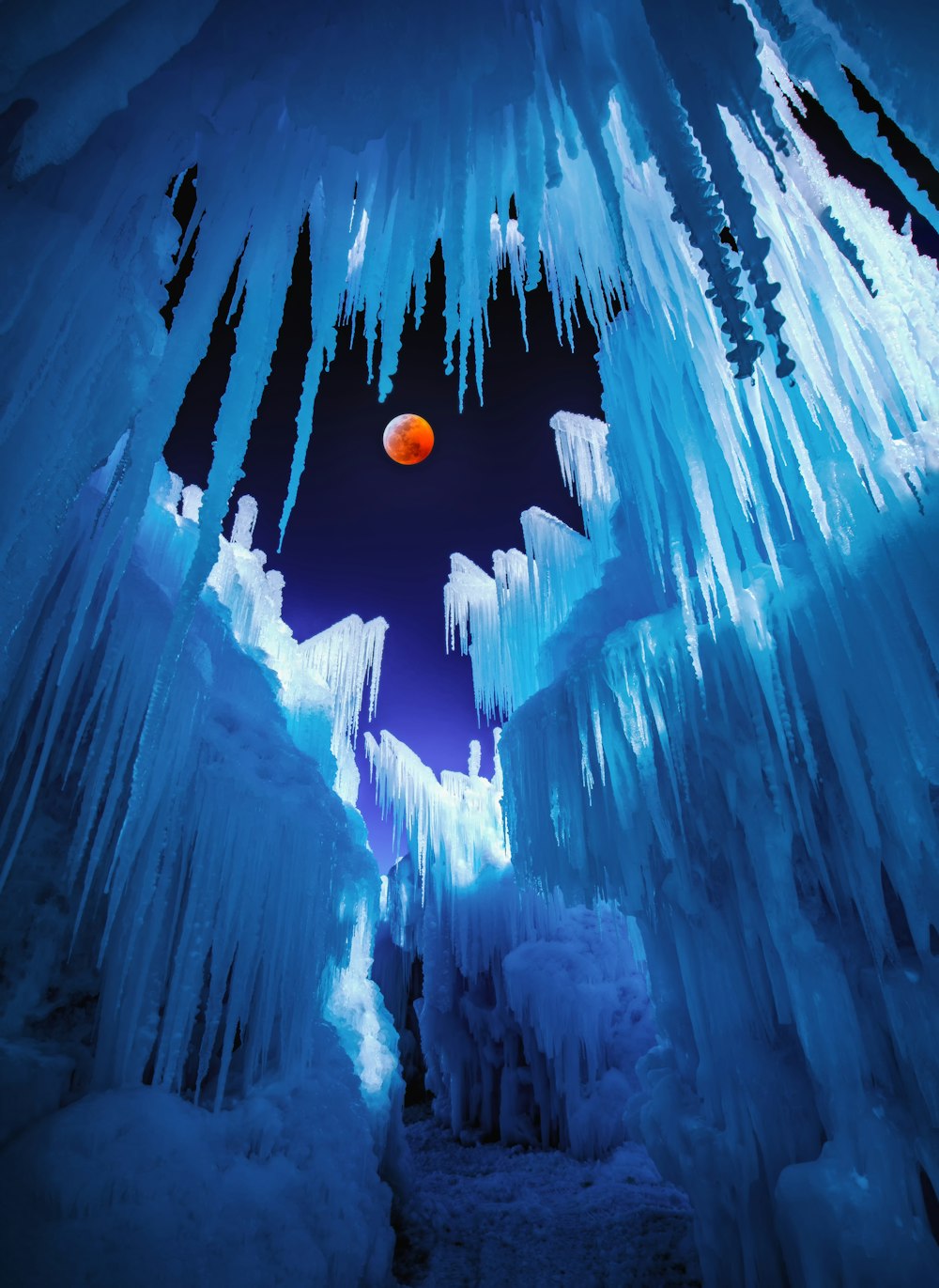 an orange ball is in the middle of ice formations