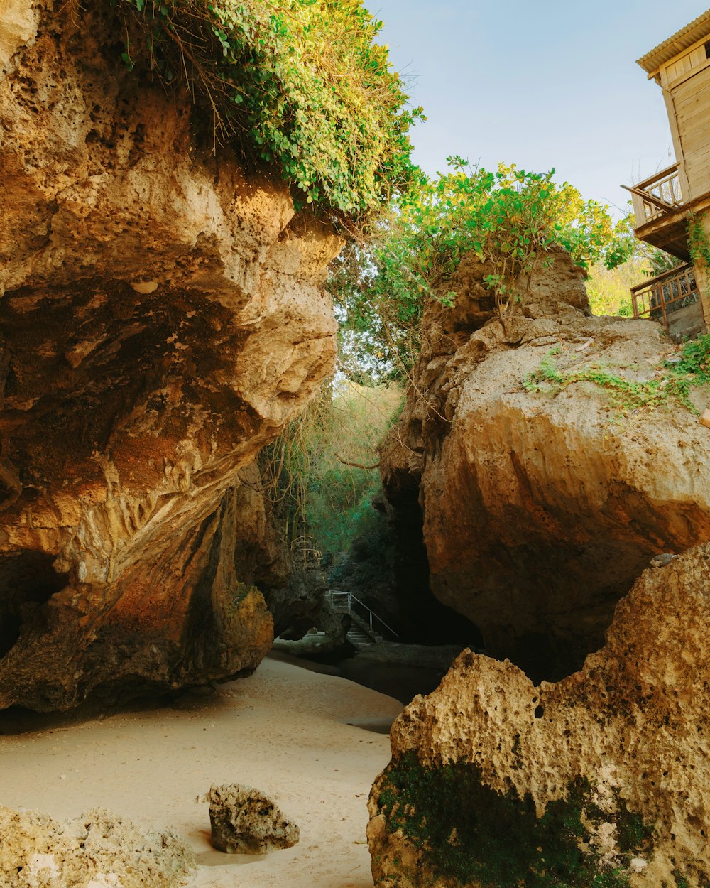 a large rock formation with a house in the background