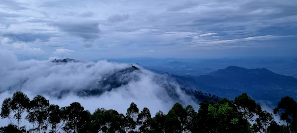 Narrow walking path along a cliff edge, stone parapet, valley far below filling with morning cloud