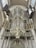 A large and ornate pipe organ is mounted within an interior space that features classical architecture. The organ is embellished with intricate designs and gilded accents. Surrounding the organ are decorative banners and columns, adding to the grandiose and historical ambiance.