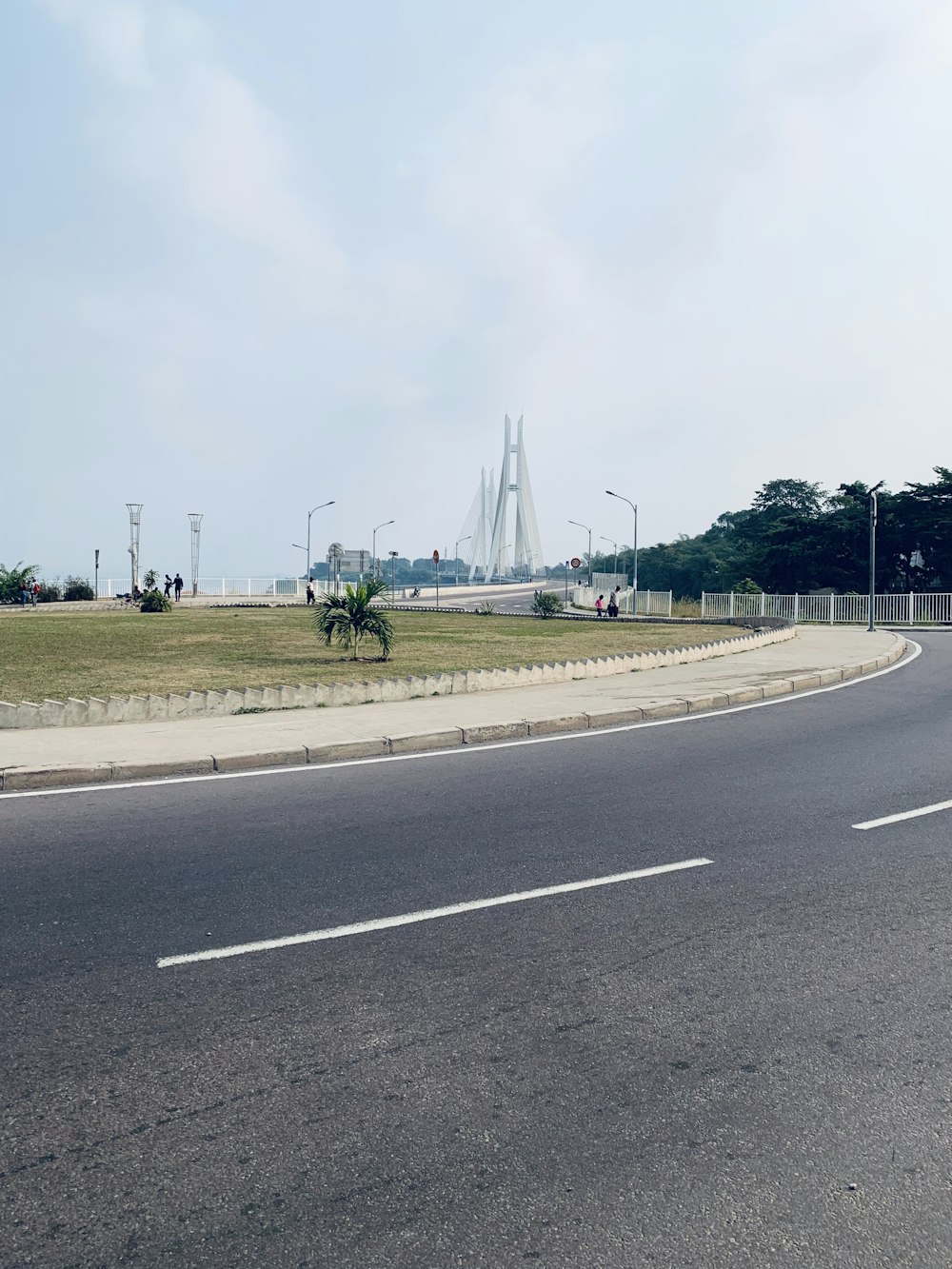 a curved road with a bridge in the background