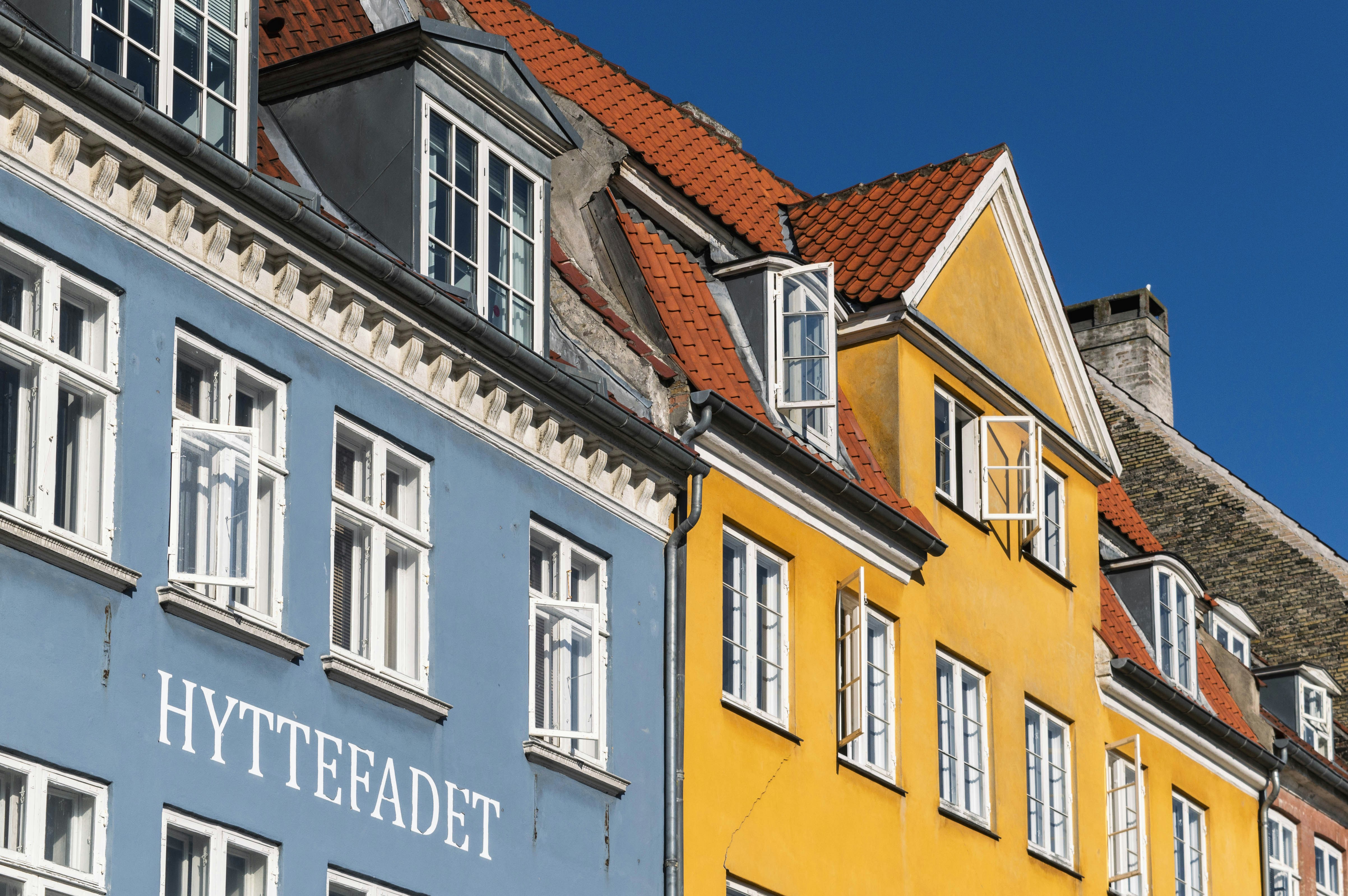 a row of colorful buildings with white windows, 