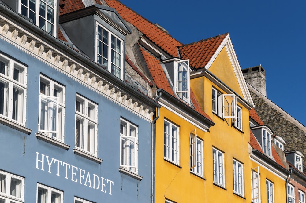 a row of colorful buildings with white windows