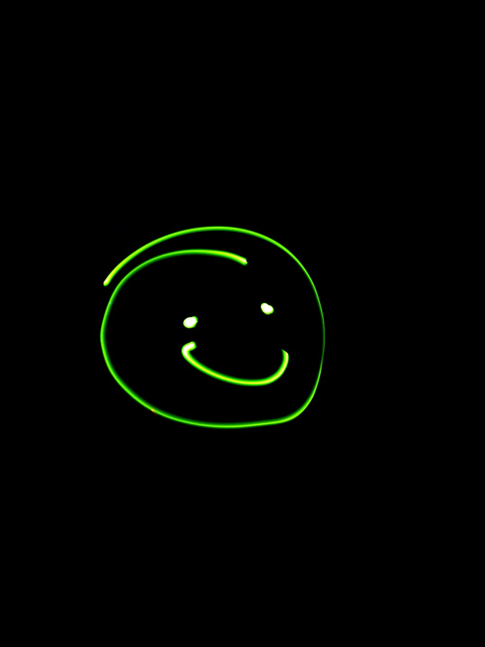 a green smiley face on a black background