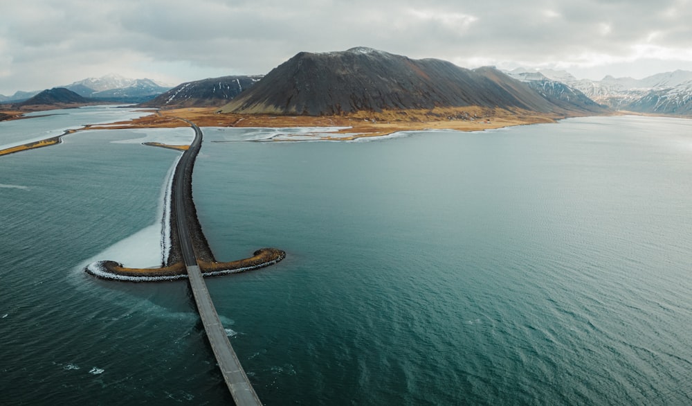 an aerial view of a road crossing over a body of water