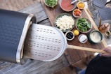A wooden table set with various gourmet pizzas and fresh ingredients.