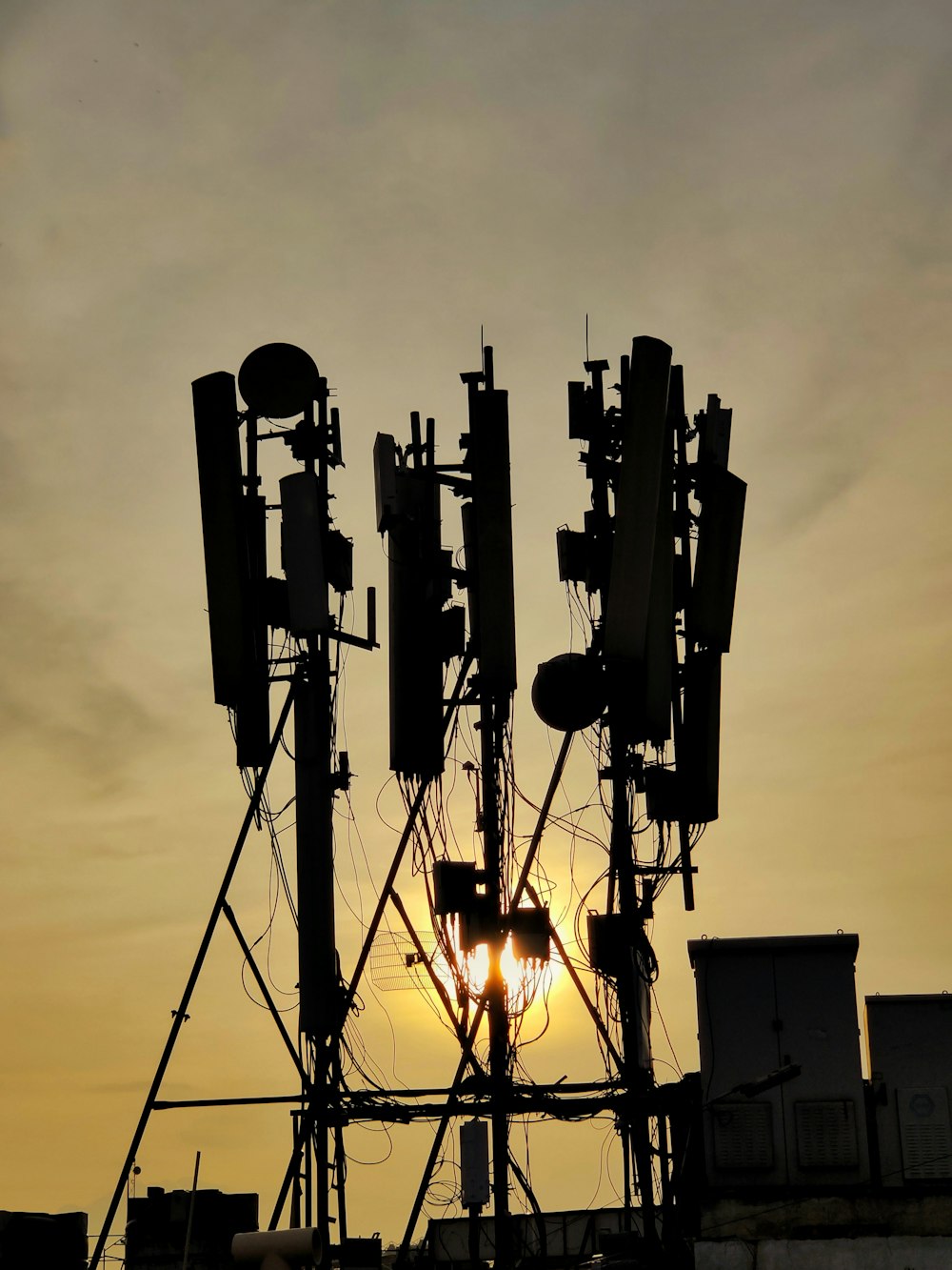 the sun is setting behind a tower of cell phones