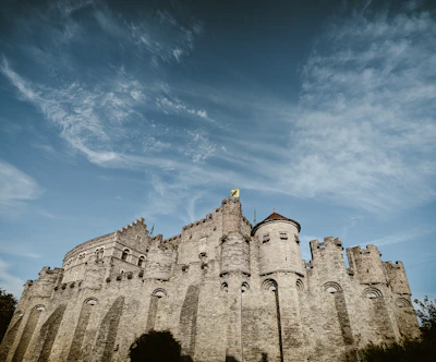 A detailed medieval fortress wall with banners fluttering in the wind.